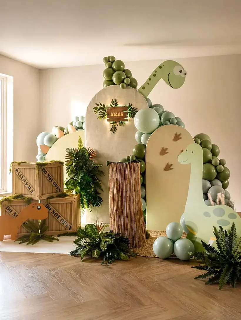 Sage green dinosaur themed children's birthday party styling in Cobham by River Fox Events — personalised name sign, balloon garland and lush foliage