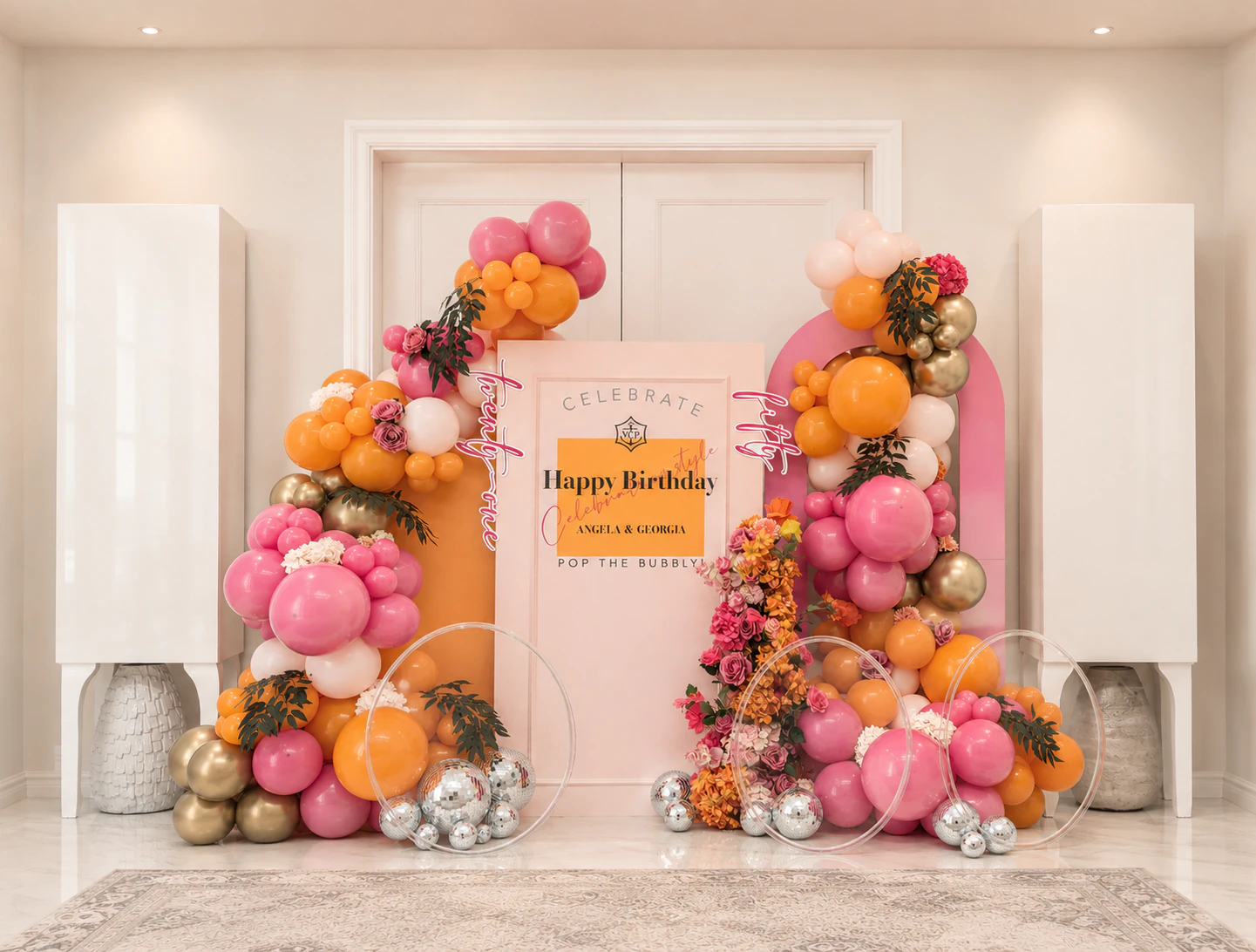 Champagne-themed milestone birthday arch in tangerine, white and gold balloons for Angela and Georgia, styled in Surrey by River Fox Events