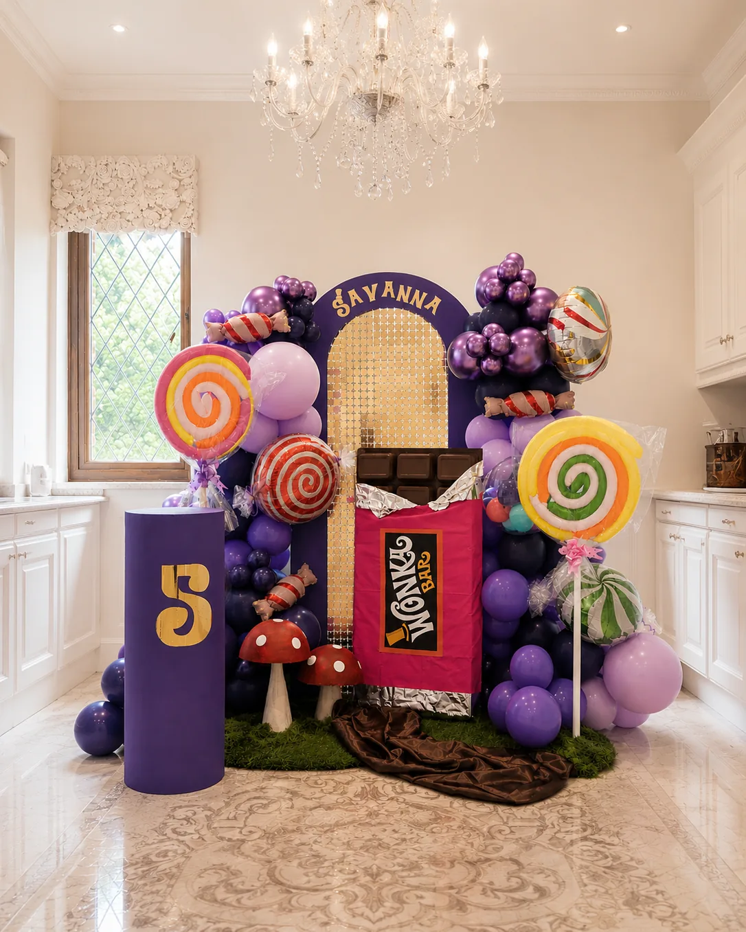 Purple and lilac balloon arch with a gold 'Savanna' ticket panel, painted cocoa-bar plinth, lollipop swirls and a purple number 5 column.